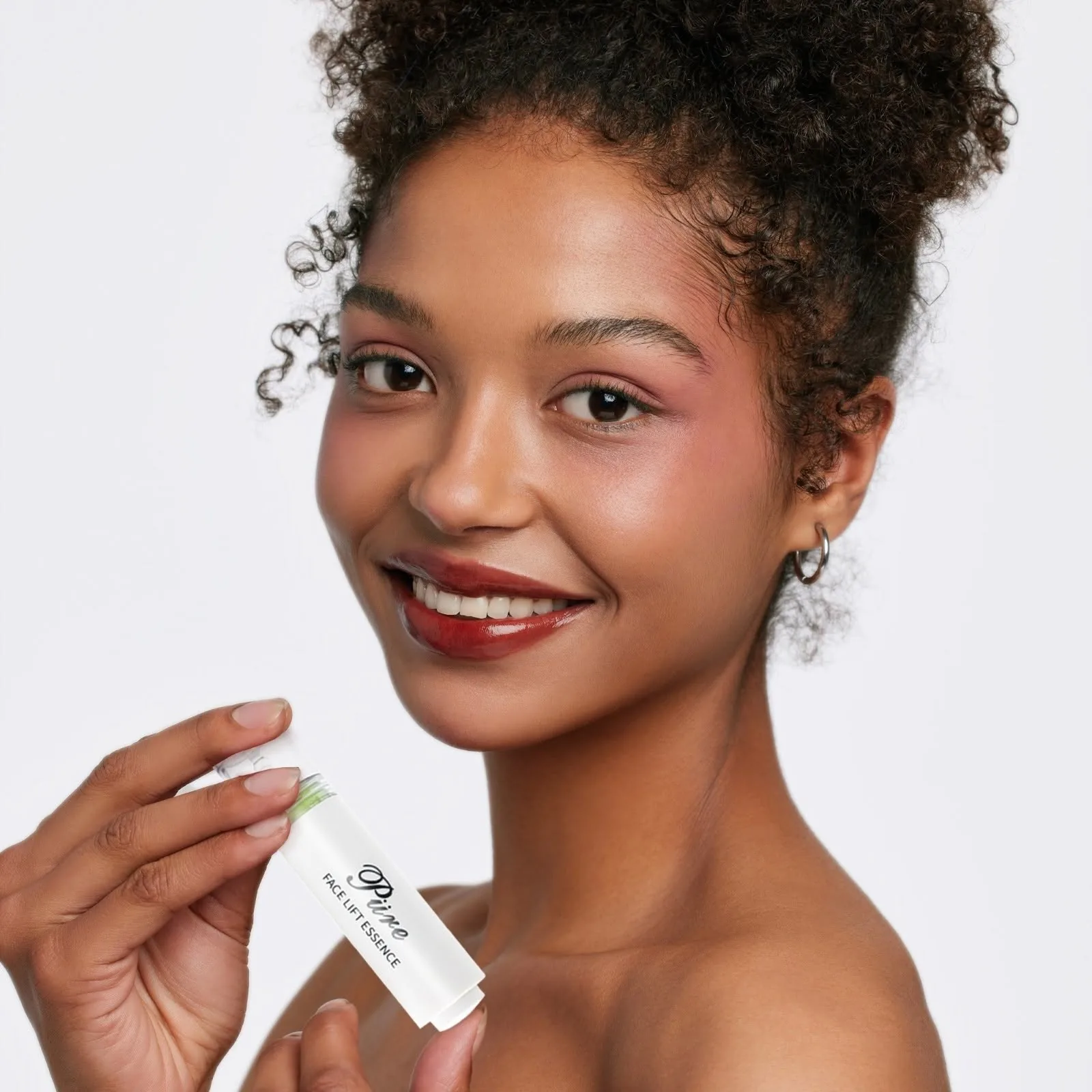 Woman smiling, holding a SkinMed product